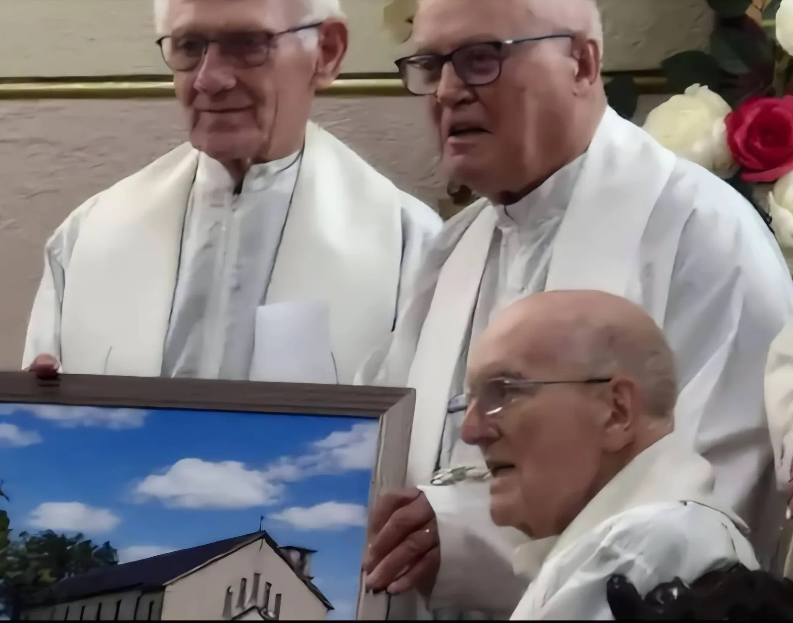 Priests at the reception in the community centre, with a framed picture of Ardagh Church