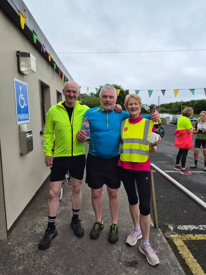 Three cyclists in hi-vis outside the community centre on the morning of the cycle
